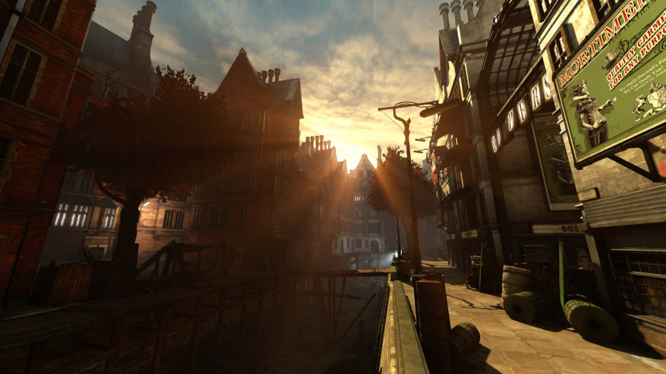 The sun breaches the distant rooftops of buildings that surround a drained canal. To the right, a decrepit market building stands illuminated in the orange glow of light, whilst the opposite side of the canal is still drenched in darkness