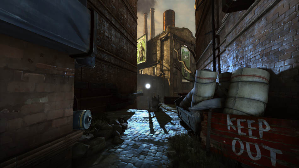 A damp alley, illuminated by a bright white lamp, with a tall building in the distance bathed in the orange glow of the morning sun. A hand painted, sign, white paint on red, reads 'KEEP OUT'. Bolts of cloth larger than a human in both height and girth, and strewn about the alley.